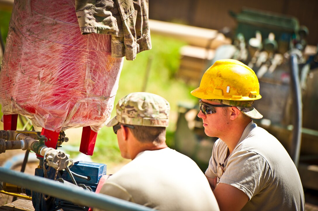 (Front right to left) Senior Airmen Jared Chapman and Benjamin Frazier, members of the 577th Expeditionary Prime Base Engineer Emergency Force Squadron Consolidated-Small Maintenance and Repair Team, inspect the mechanism of a water pump connected to a showering facility at Combat Outpost Azimijan Kariz, Afghanistan, April 30, 2013. The C-SMART, made up of six people from different civil engineer specialties, made their second of two visits to COP AJK to improve life, health and safety areas around the compound. (U.S. Air Force photo/Senior Airman Scott Saldukas)