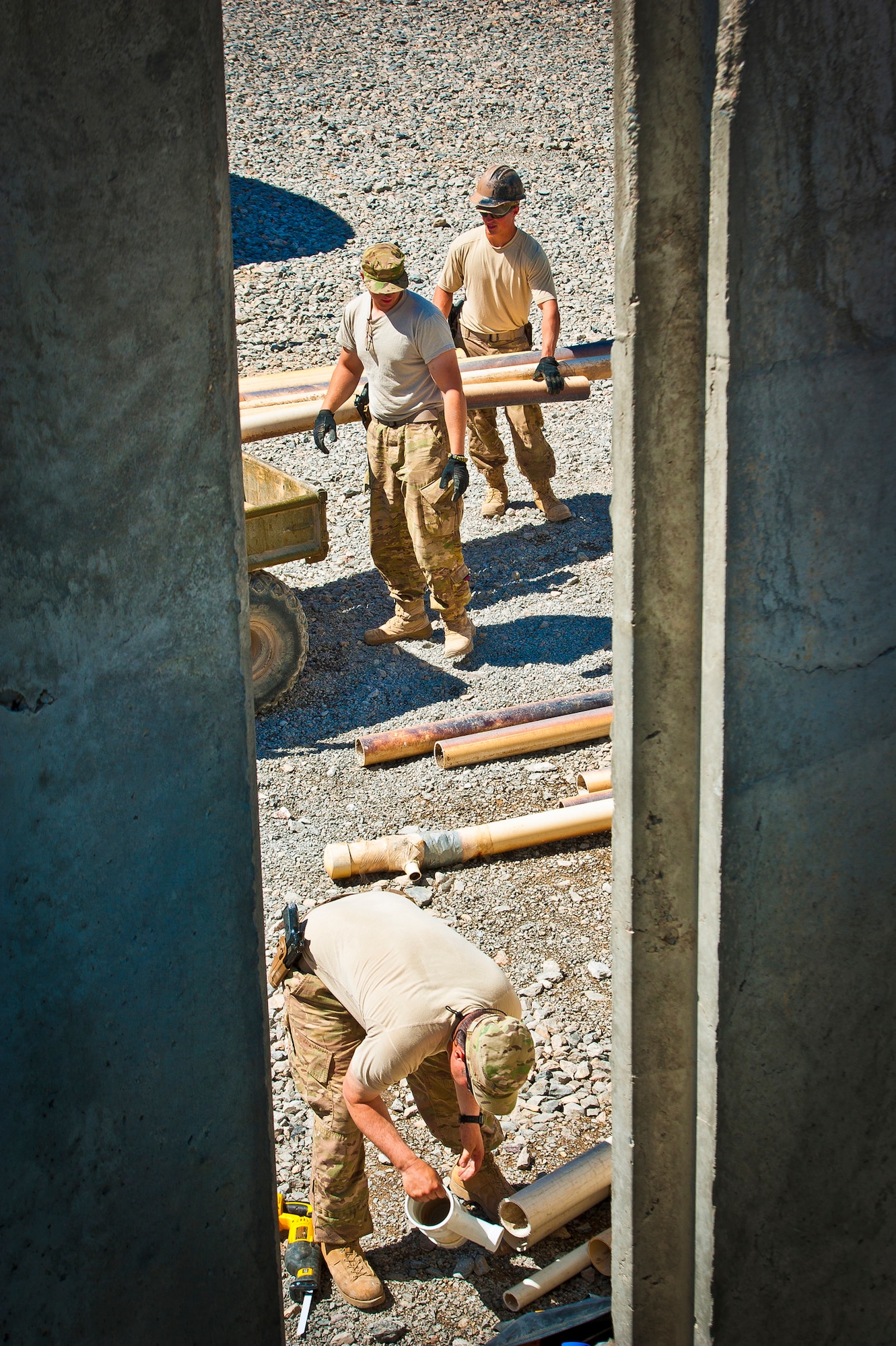 (Front to back) Tech. Sgt. Chris Mason, Senior Airmen Jared Chapman and Benjamin Frazier, all members of the 577th Expeditionary Prime Base Engineer Emergency Force Squadron Consolidated-Small Maintenance and Repair Team, prepare a work site that ultimately required 200 feet of new piping to be installed at Combat Outpost Azimijan Kariz, Afghanistan, April 30, 2013. The C-SMART is one of two teams stationed at Kandahar Airfield, Afghanistan. (U.S. Air Force photo/Senior Airman Scott Saldukas)