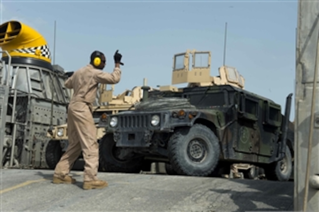 U.S. Navy Petty Officer 2nd Class Dwayne Todd directs the driver of a Humvee as he backs into a Landing Craft Air Cushion during exercise Eagle Resolve 2013 in Doha, Qatar, on May 4, 2013.  Eagle Resolve is an annual multilateral exercise designed to enhance regional cooperative defense efforts of the Gulf Cooperation Council nations and U.S. Central Command.  
