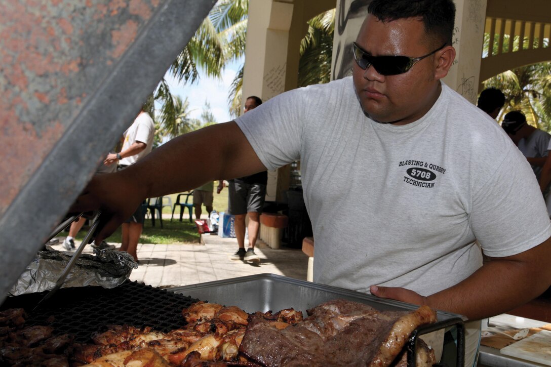 Garrett Agun prepares food at Nimitz Beach, Guam, April 27. As a way to show their appreciation, veterans and the 3rd Marine Division Association hosted Marines who have been participating in Exercise Guahan Shield. The Marines in attendance are with Combat Logistics Detachment 39, which is comprised of elements of 9th Engineer Support Battalion and Company L, 3rd Bn., 6th Marines. Photo by Lance Cpl. Pete Sanders