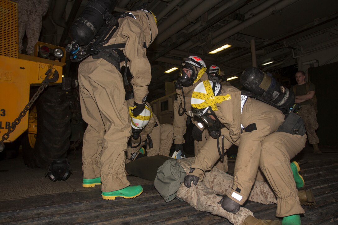 Chemical, biological, radiological and nuclear defense specialist U.S. Marines assigned to the 26th Marine Expeditionary Unit (MEU), assess a simulated casualty during a confined space search and rescue in a hazardous environment exercise, in the hangar bay of the USS Kearsarge (LHD 3), while underway, May 8, 2013. The 26th MEU is deployed to the 5th Fleet area of operations aboard the Kearsarge Amphibious Ready Group. The 26th MEU operates continuously across the globe, providing the president and unified combatant commanders with a forward-deployed, sea-based quick reaction force. The MEU is a Marine Air-Ground Task Force capable of conducting amphibious operations, crisis response and limited contingency operations. (U.S. Marine Corps photograph by Cpl. Kyle N. Runnels/Released)