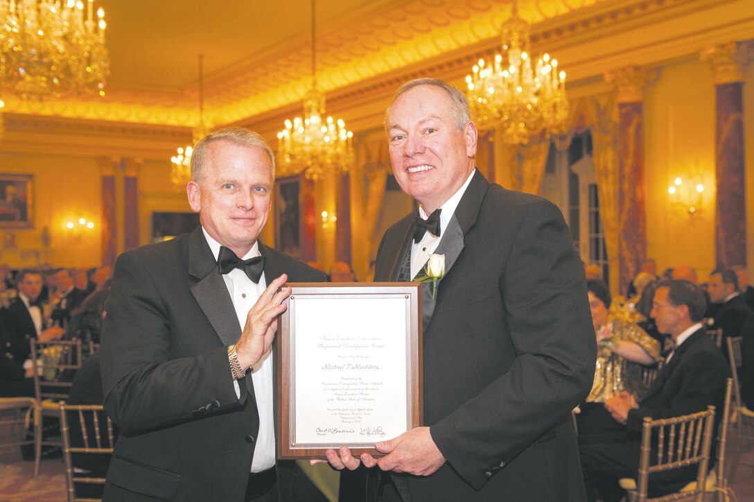 Michael T. Madden, right, receives a Certificate of Honor from Eric Coulter, treasurer, Senior Executive Association's Board of Directors, at the 28th annual black tie Distinguished Rank Awards Banquet held at the State Department Diplomatic Reception Rooms in Washington D.C., April 25.