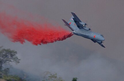 U.S. Air Force C-130E from the 146th Airlift Wing, Channel Island Air National Guard, dispenses fire retardent on the Simi fire in southern California. 