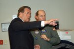 Secretary of Homeland Security Tom Ridge and Navy Capt. Brad Johanson discuss the capabilities of the United States Northern Command (USNORTHCOM) Domestic Warning Center.
