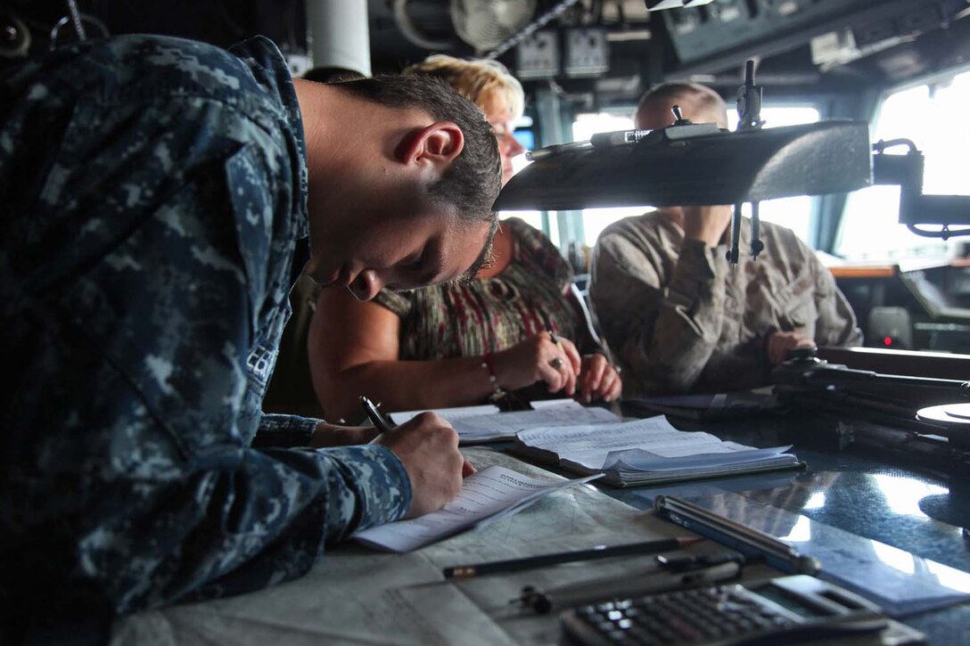 Seaman Joseph A. Gleeson, quartermaster, Ship’s Company, USS Peleliu, autographs a booklet for a Marine’s mother during a tour of USS Peleliu, May 7.  During the last leg of the 15th Marine Expeditionary Unit’s deployment, families and friends came aboard the ship to experience life on the Peleliu and to learn what their Marine or sailor has accomplished during the past seven months. The 15th MEU is comprised of approximately 2,400 Marines and sailors and is deployed as part of the Peleliu Amphibious Ready Group. Together, they provide a forward-deployed, flexible sea-based Marine Air Ground Task Force capable of conducting a wide variety of operations ranging from humanitarian aid to combat. Gleeson, 21, is from Alvin, Texas. (U.S. Marine Corps photo by Cpl. Timothy Childers/Released)
