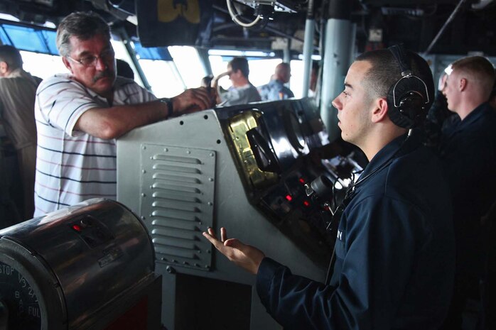 Seaman Joseph A. Toth, deck crewman, Ship’s Company, USS Peleliu, explains his job to a sailor’s family member during a tour of USS Peleliu, May 7.  During the last leg of the 15th Marine Expeditionary Unit’s deployment, families and friends came aboard the ship to experience life on the Peleliu and to learn what their Marine or sailor has accomplished during the past seven months. The 15th MEU is comprised of approximately 2,400 Marines and sailors and is deployed as part of the Peleliu Amphibious Ready Group. Together, they provide a forward-deployed, flexible sea-based Marine Air Ground Task Force capable of conducting a wide variety of operations ranging from humanitarian aid to combat. Toth, 19, is from Columbus, Ohio. (U.S. Marine Corps photo by Cpl. Timothy Childers/Released)