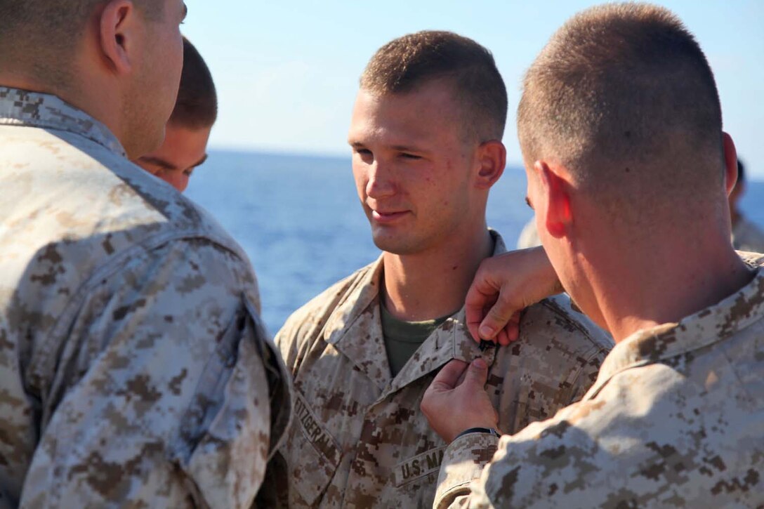 Corporal Brandon L. Fitzgerald, field artillery cannoneer, 1st Platoon, Battery B, Battalion Landing Team 3/5, 15th Marine Expeditionary Unit, is promoted to the rank of corporal during a promotion ceremony aboard USS Rushmore, May 1. The 15th MEU is comprised of approximately 2,400 Marines and sailors and is deployed as part of the Peleliu Amphibious Ready Group. Together, they provide a forward-deployed, flexible sea-based Marine Air Ground Task Force capable of conducting a wide variety of operations ranging from humanitarian aid to combat. Fitzgerald, 24, is from Auroa, Ill. (U.S. Marine Corps photo by Cpl. Timothy Childers / Released)