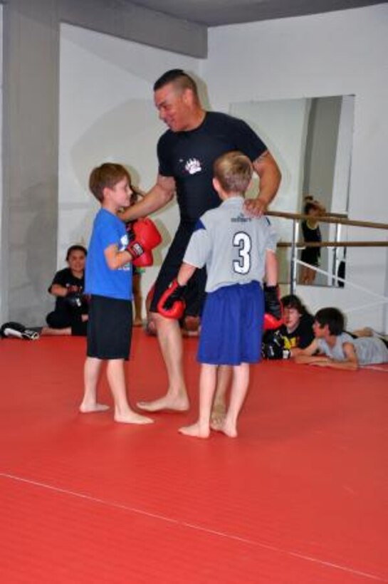 uan Rivera, the information technology officer on Marine Corps Logistics Base Barstow, talks to two students enrolled in his mixed martial arts course, May 2. The students just finished sparring and Rivera declared them both champions.



