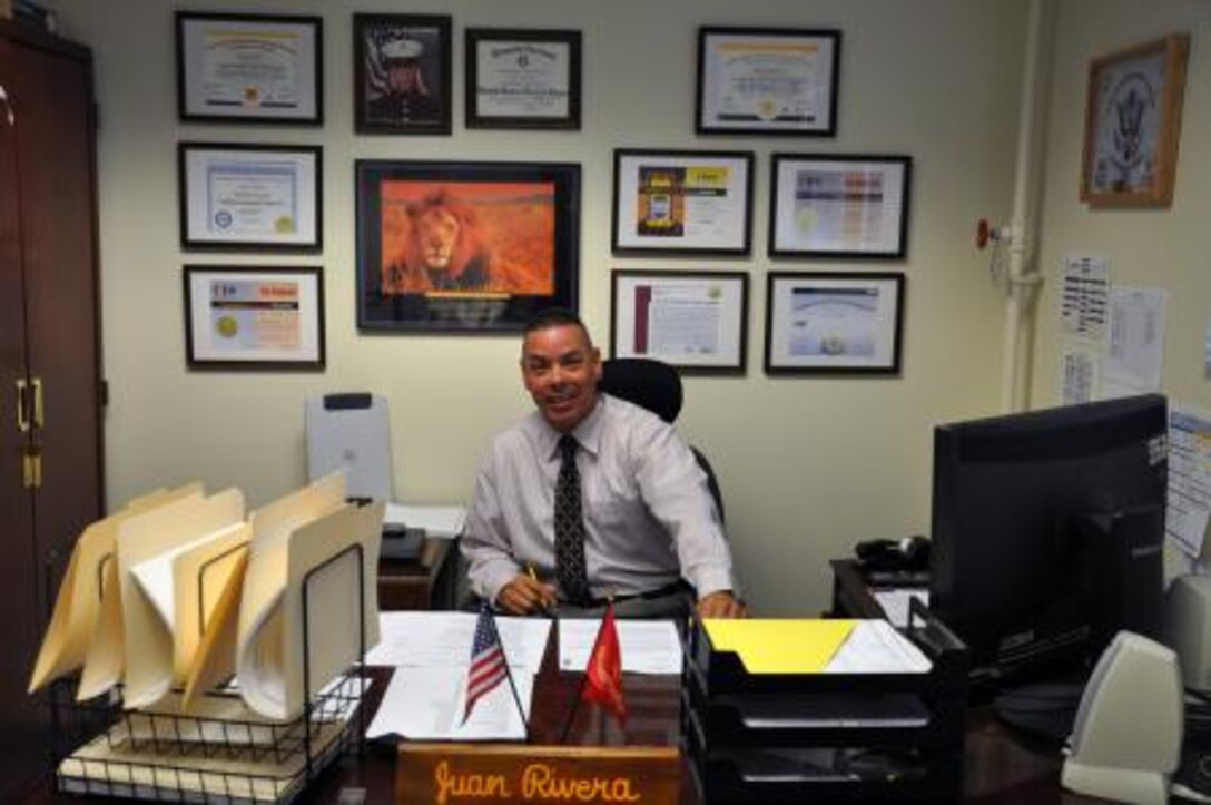 Juan Rivera, the information technology officer on Marine Corps Logistics Base Barstow, poses for a photo at his desk, May 7. Rivera has 14 certifications in the cyber security world displayed in his office.