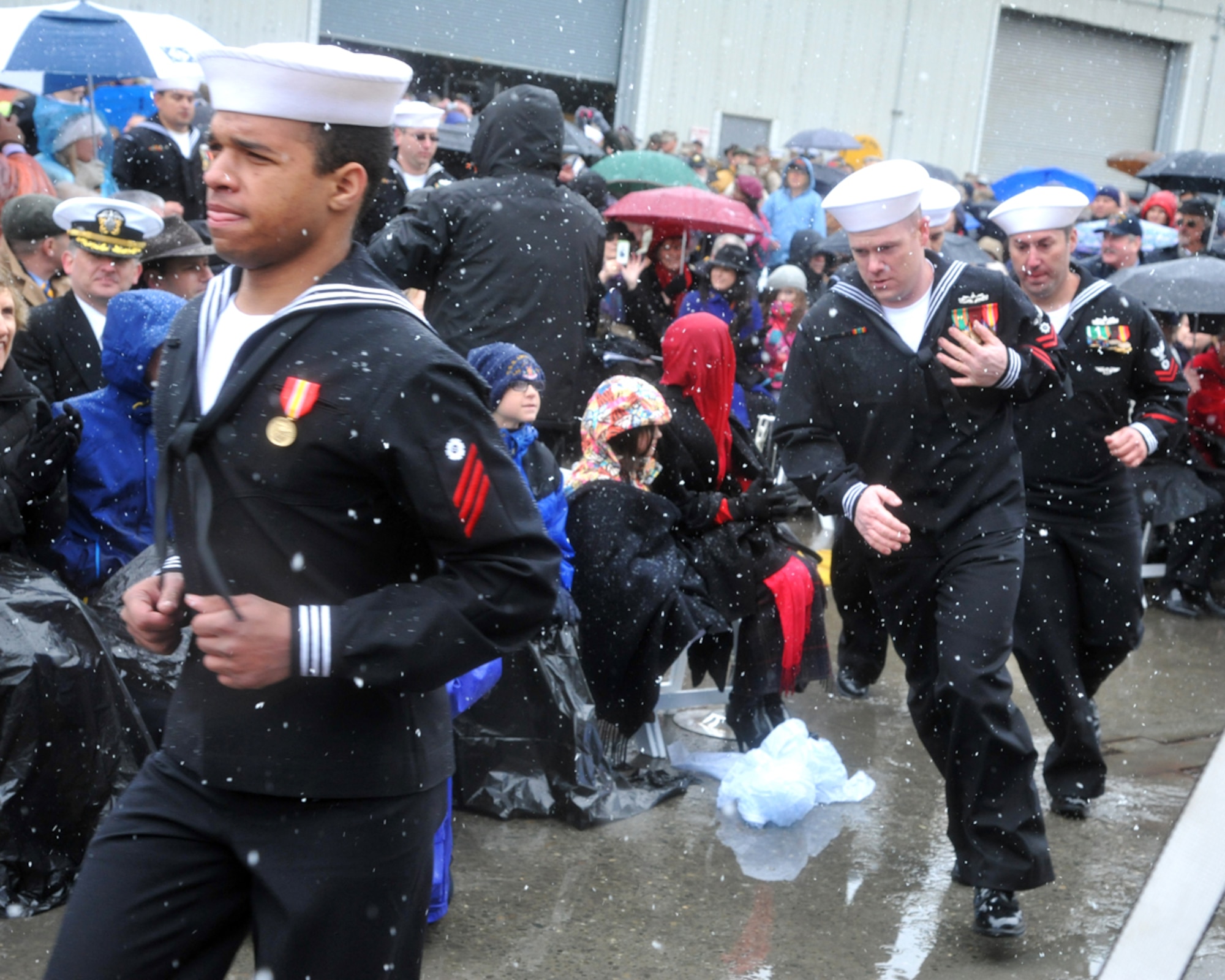 130504-F-IY975-015: JOINT BASE ELMENDORF-RICHARDSON, Alaska -- Crew members of the Navy’s newest ship, the USS Anchorage, run to board her following the ship’s commissioning ceremony at the Port of Anchorage May 4. The amphibious transport dock ship is the second Navy vessel to bare the name of Alaska’s largest city. (U.S. Air Force photo/Senior Airman Blake Mize)