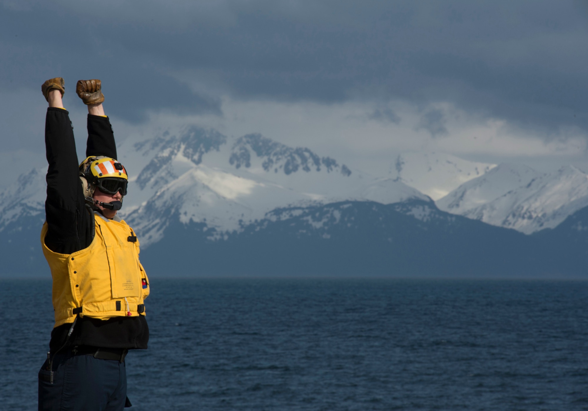 COOK INLET, Alaska -- Aviation Boatswain's Mate (Fuel) Richard St. Clair directs the recovery of helicopters April 30, 2013, on the flight deck as the San Antonio-class amphibious transport dock ship Pre-Commissioning Unit (PCU) Anchorage (LPD 23) approaches the coast of Alaska. Anchorage is en route to its namesake city of Anchorage, Alaska, for its commissioning ceremony May 4. (U.S. Navy photo/Petty Officer 1st Class James R. Evans)