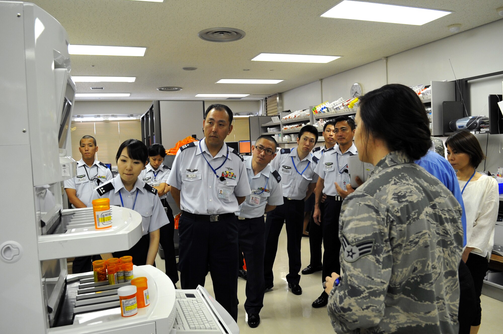 U.S. Air Force Senior Airman Tegan Davis, 18th Medical Support Squadron pharmacy technician, explains the Pharmassist Robot X distribution system of medicine to the Japan Air Self Defense Force (JASDF) medical staff during a visit to the 18th Medical Group on Kadena Air Base, Japan, May 7, 2013. The JASDF medical staff visited the squadron to learn more about the Air Force's medical systems as well as build friendships with their American counterparts. (U.S. Air Force photo by Naoto Anazawa/Released)