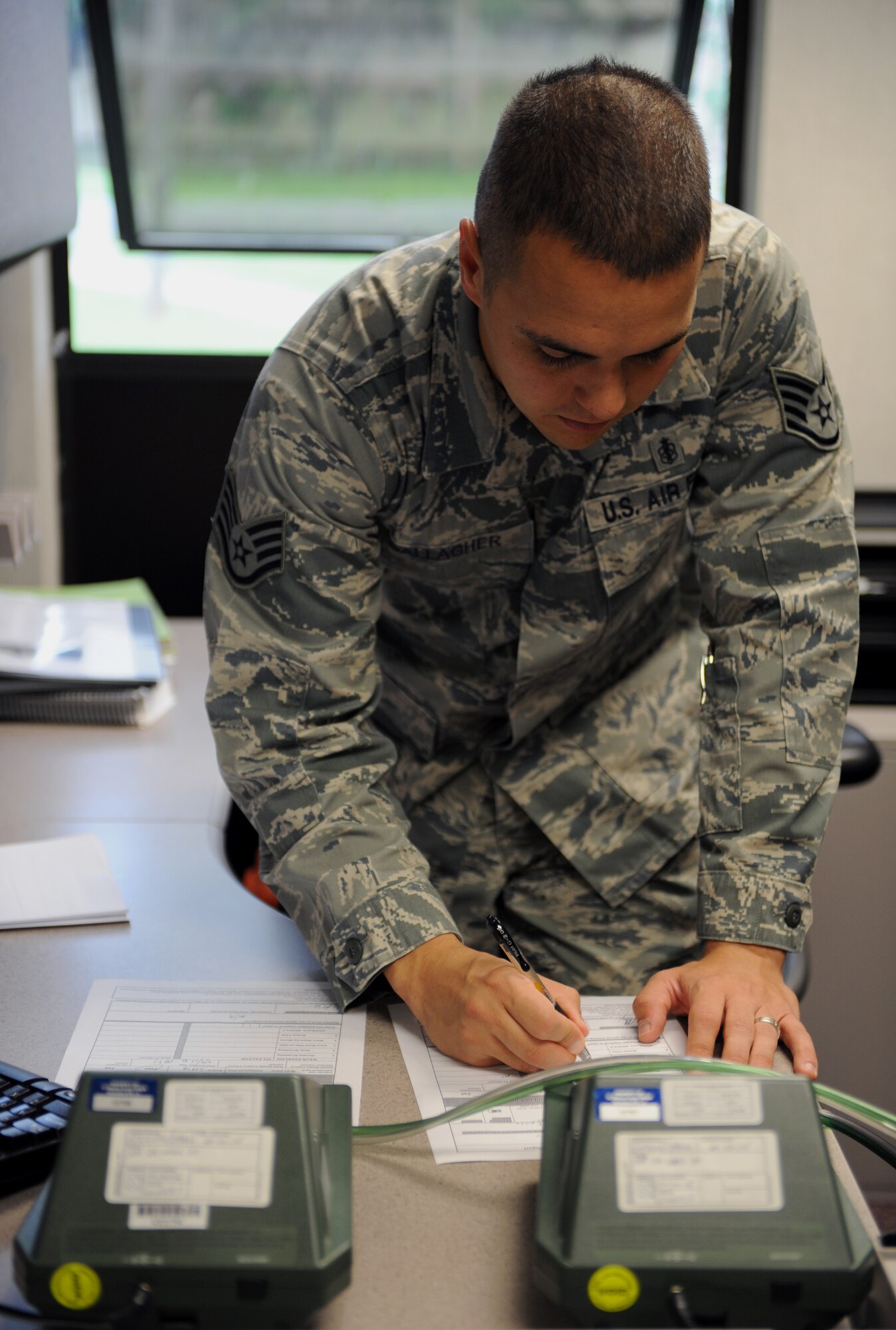 Staff Sgt. Shawn Gallagher, 2nd Aerospace Medical Squadron, annotates the readings off a photocount plus machine on Barksdale Air Force Base, La., May 9, 2013. During a gas mask fit test, a photocount plus machine measures the particle readings from the air in the room and compares it to the air found in the gas masks to ensure the masks are sealed properly. (U.S. Air Force photo/Airman 1st Class Benjamin Gonsier)
