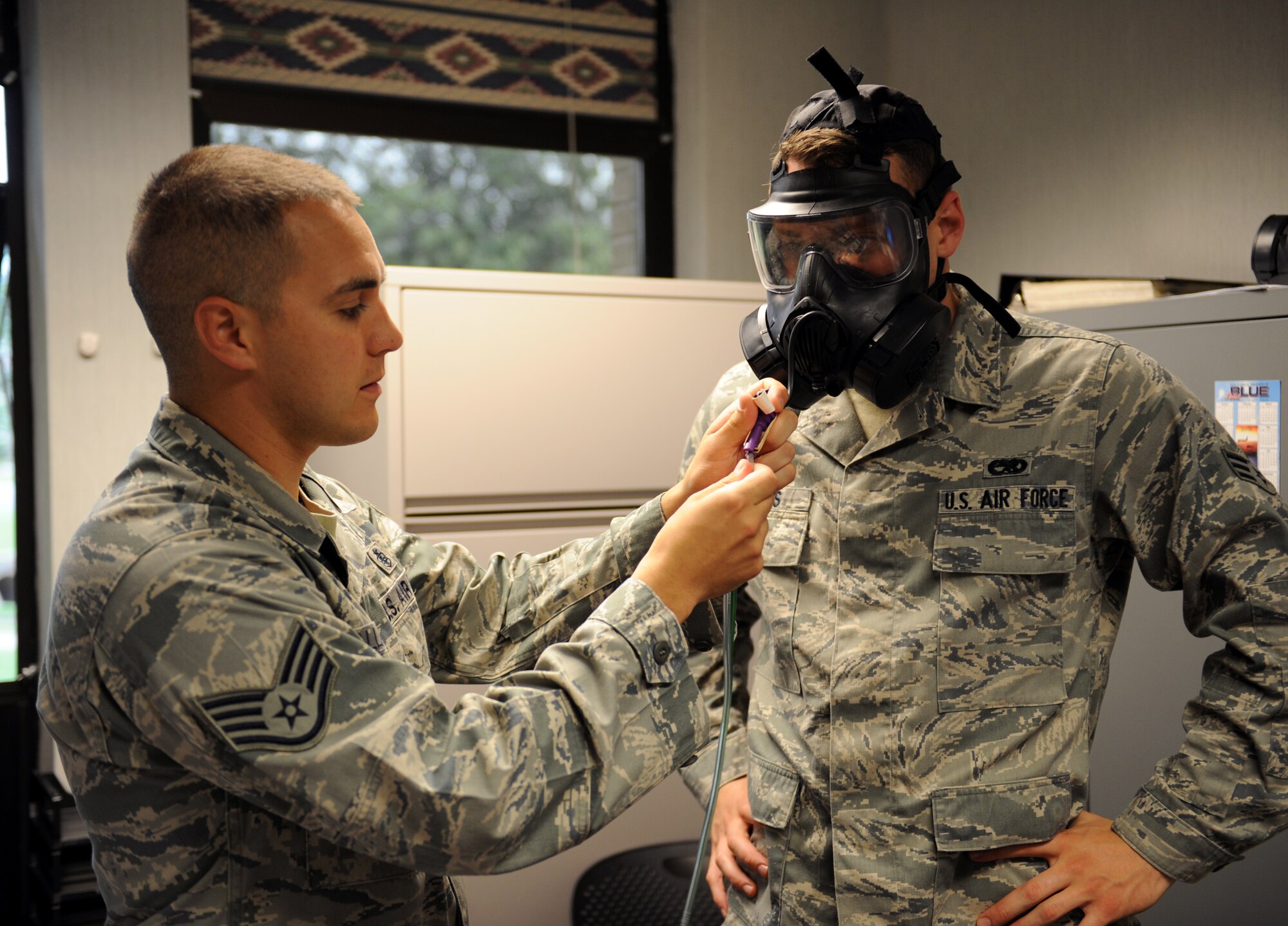 Staff Sgt. Shawn Gallagher, 2nd Aerospace Medical Squadron, connects an M-50 Joint Service General Purpose Mask to a photocount plus machine on Barksdale Air Force Base, La., May 9, 2013. During the test, a photocount plus machine measures the particle readings from the air in the room and compares it to the air found in the gas masks to ensure the masks are sealed properly. (U.S. Air Force photo/Airman 1st Class Benjamin Gonsier)
