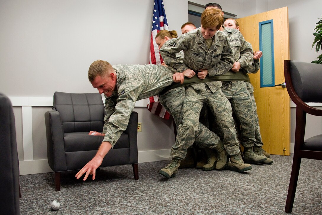 GRISSOM AIR RESERVE BASE, Ind. -- Staff Sgt. Aaron Williams, 434th Aerospace Medicine Squadron health services craftsman, stretches to reach a toy brain during a scavenger hunt as Staff Sgt. Christina Rudell, a 434th AMDS health services management apprentice, and other members of the 434th AMDS, use teamwork to support him during Wingman Day here April 14. Units and organizations across the base participated in several such exercises aimed at improving unit cohesion, communication and interpersonal relationships during Wingman Day. (U.S. Air Force photo/Maj. Kelly Howard)