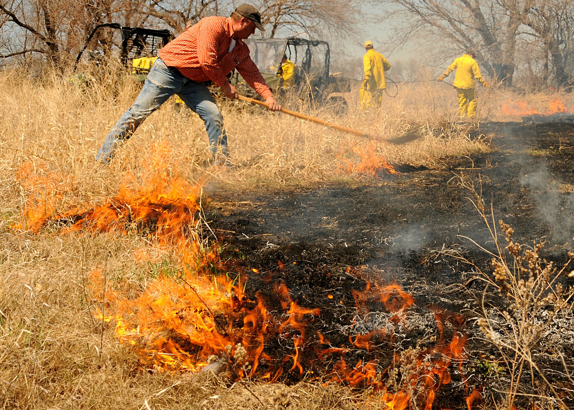 Carl Piper, 319th Civil Engineer Squadron contractor, uses a flapper tool to help put out part of a 60-acre controlled fire May 7, 2013, in the area across from the main gate of Grand Forks Air Force Base, N.D. The purpose of the prescribed burn was to rid the site of woody encroachment, regulate growing weeds and to conserve the habitat. (U.S. Air Force photo/Airman 1st Class Xavier Navarro)    