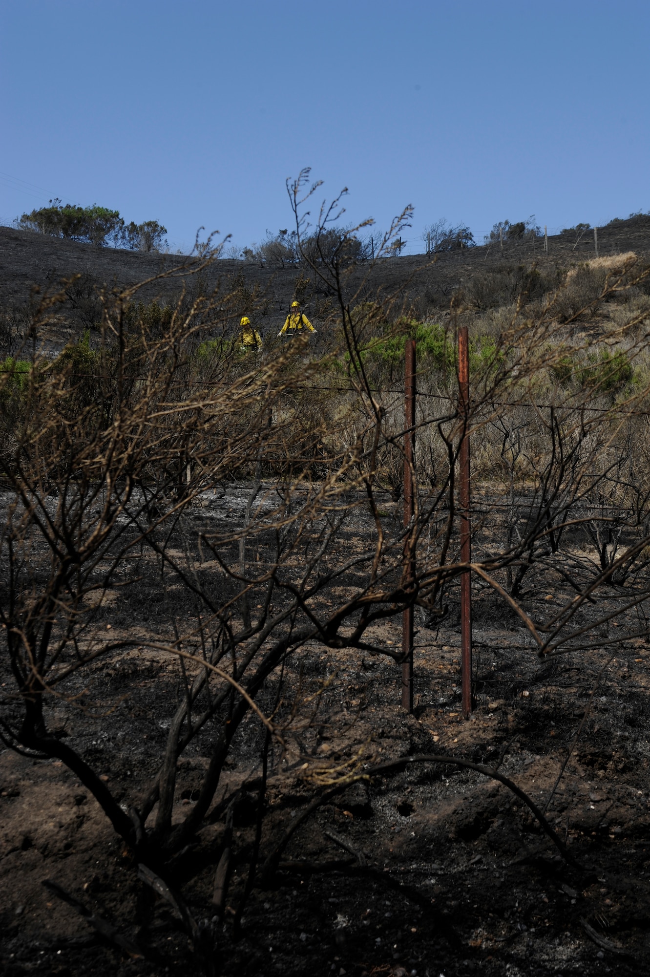 VANDENBERG AIR FORCE BASE, Calif. – Vandenberg firefighters breakup and bury smoldering ashes after containing a brush fire on Highway 1 here Wednesday, May 9, 2013. The Vandenberg Fire Department, Santa Barbara County Fire Department and the U.S. Forest Service joined forces to control the 10 acre fire within two hours. (U.S. Air Force photo/Senior Airman Lael Huss)