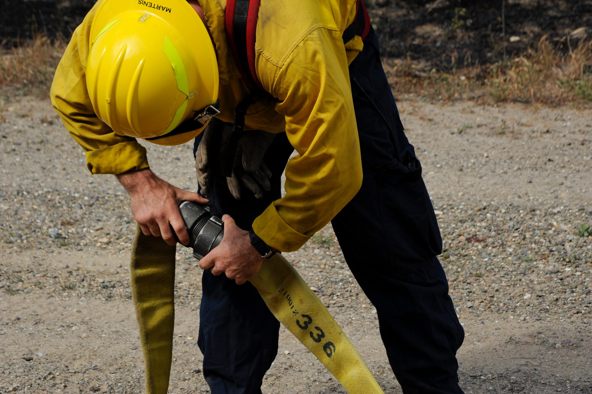 VANDENBERG AIR FORCE BASE, Calif. – A Team V firefighter connects hoses together during a brush fire on Highway 1 here Wednesday, May 9, 2013. Vandenberg firefighters were the first responders to the 10 acre fire and, with the help of the Santa Barbara County Fire Department and the U.S. Forest Service, contained the fire within two hours. (U.S. Air Force photo/Senior Airman Lael Huss)