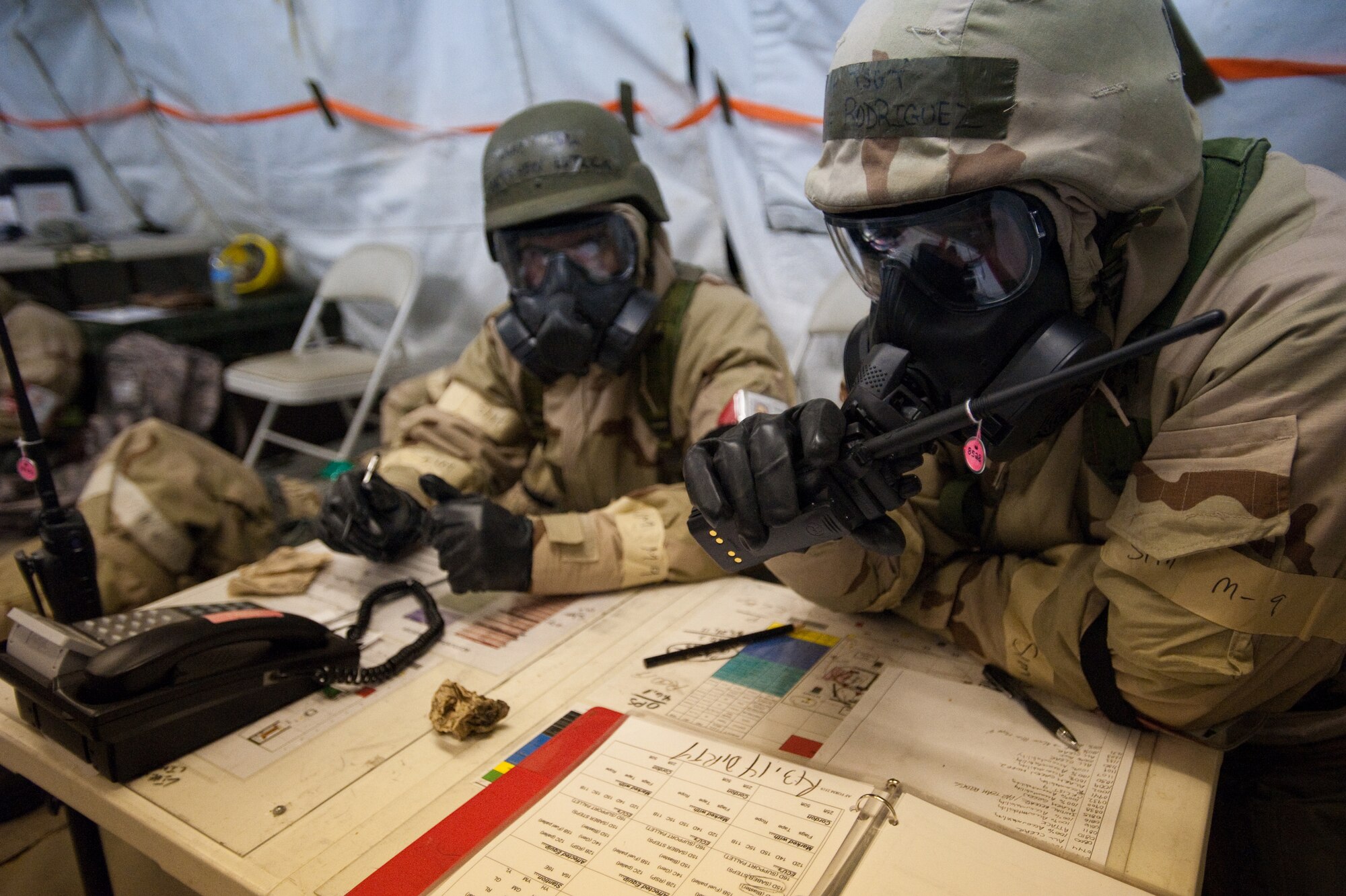 U.S. Air Force Tech. Sgt. John Rodriguez (right), from the 245th Air Traffic Control Squadron of the South Carolina Air National Guard, coordinates post-attack procedures during a Readiness Exercise at McEntire Joint National Guard Base, S.C., May 4, 2013.  His unit is simulating being attacked with chemical agents. The 245th ATCS is conducting the readiness exercise in preparation for their unit readiness inspection. This exercise will test their ability to deploy, survive and operate in a chemical, biological, radioactive, and nuclear environment. (U.S. Air National Guard photo by Staff Sgt. Jorge Intriago/Released)