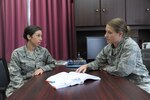 Capt. Sarah Huerta (left), 902nd Mission Support Group Judge Advocate chief of legal assistance, discusses a legal matter with Capt. Anna Rehder, 902nd Mission Support Group Judge Advocate chief of civil law, April 26 at Joint Base San Antonio-Randolph. (U.S. Air Force photo by Joel Martinez / Released)