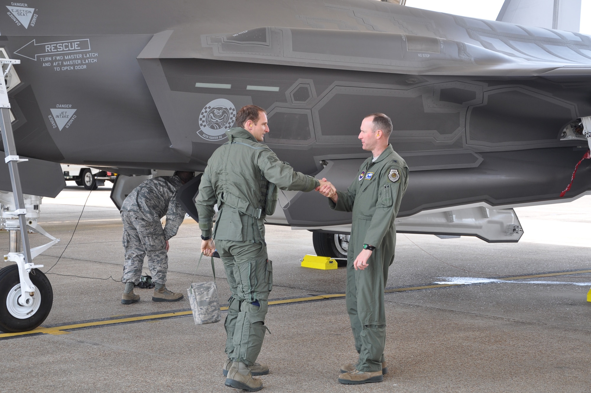 Maj. Matthew Johnston, (left) 58th Fighter Squadron, instructor pilot, shakes hands with Col.Stephen Jost, 33rd Operations Group commander upon arriving at Eglin Air Force base, Fla. with the advanced F-35 Lighting II joint strike fighter, May 6, 2013. The advanced F-35 will be utilized by all military branches at the Air Education Training Command F-35 schoolhouse to train on new systems and software on the platform.(U.S. Air Force photo by Staff Sgt. Nicholas Egebrecht)