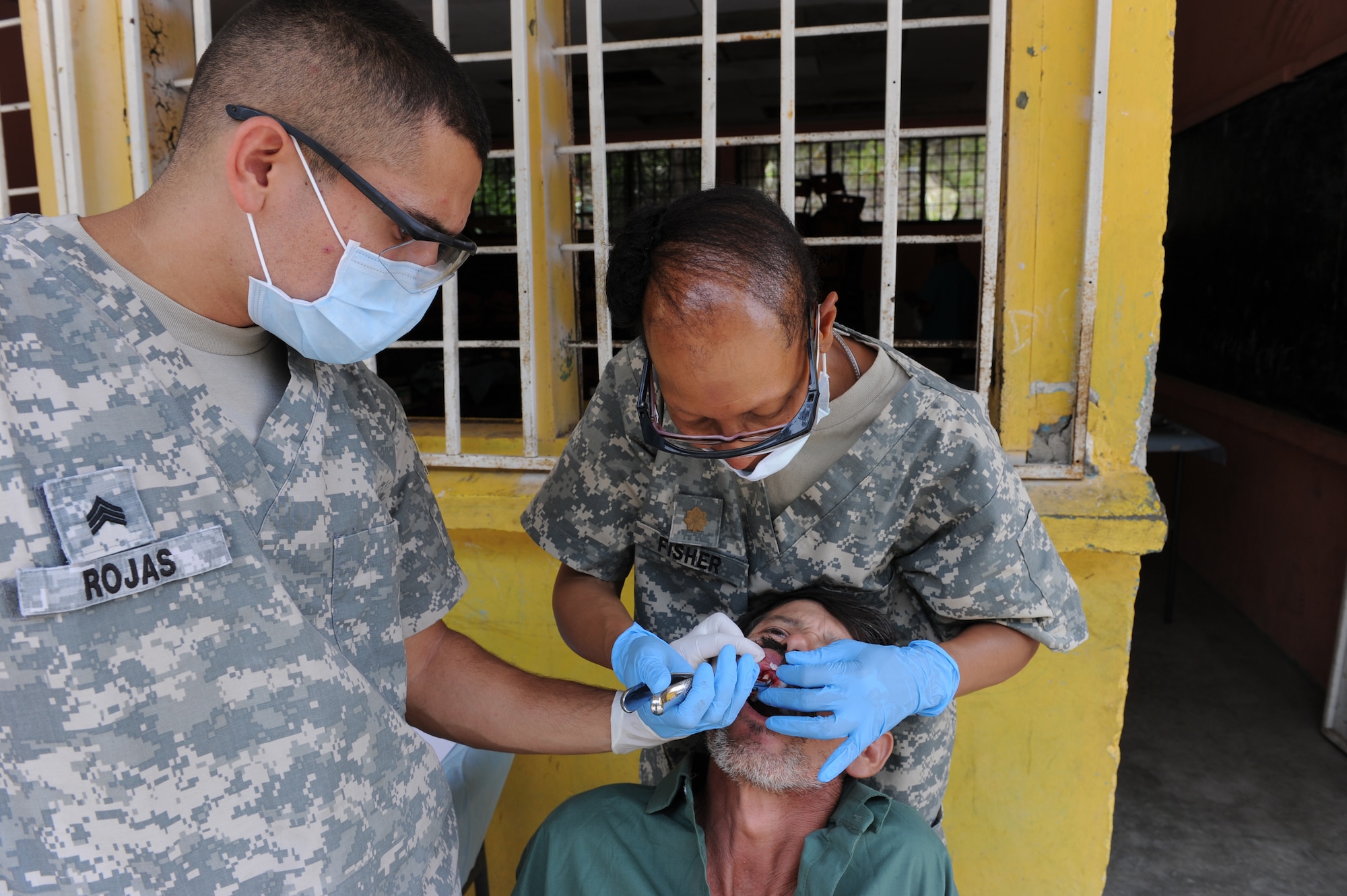 U.S. Army Sgt. Anthony Rojas, Joint Task Force-Bravo Operating Room Technician assist U.S. Army Maj. Perdita Fisher, Joint Task Force-Bravo Dentist, in a tooth extraction during a Medical Readiness exercise, May 6. Joint Task force-Bravo partnered with Honduran Ministry of Health and Honduran military personnel, to provide medical services to more than 500 Cuesta de la Virgen community members. (Photo by Martin Chahin)