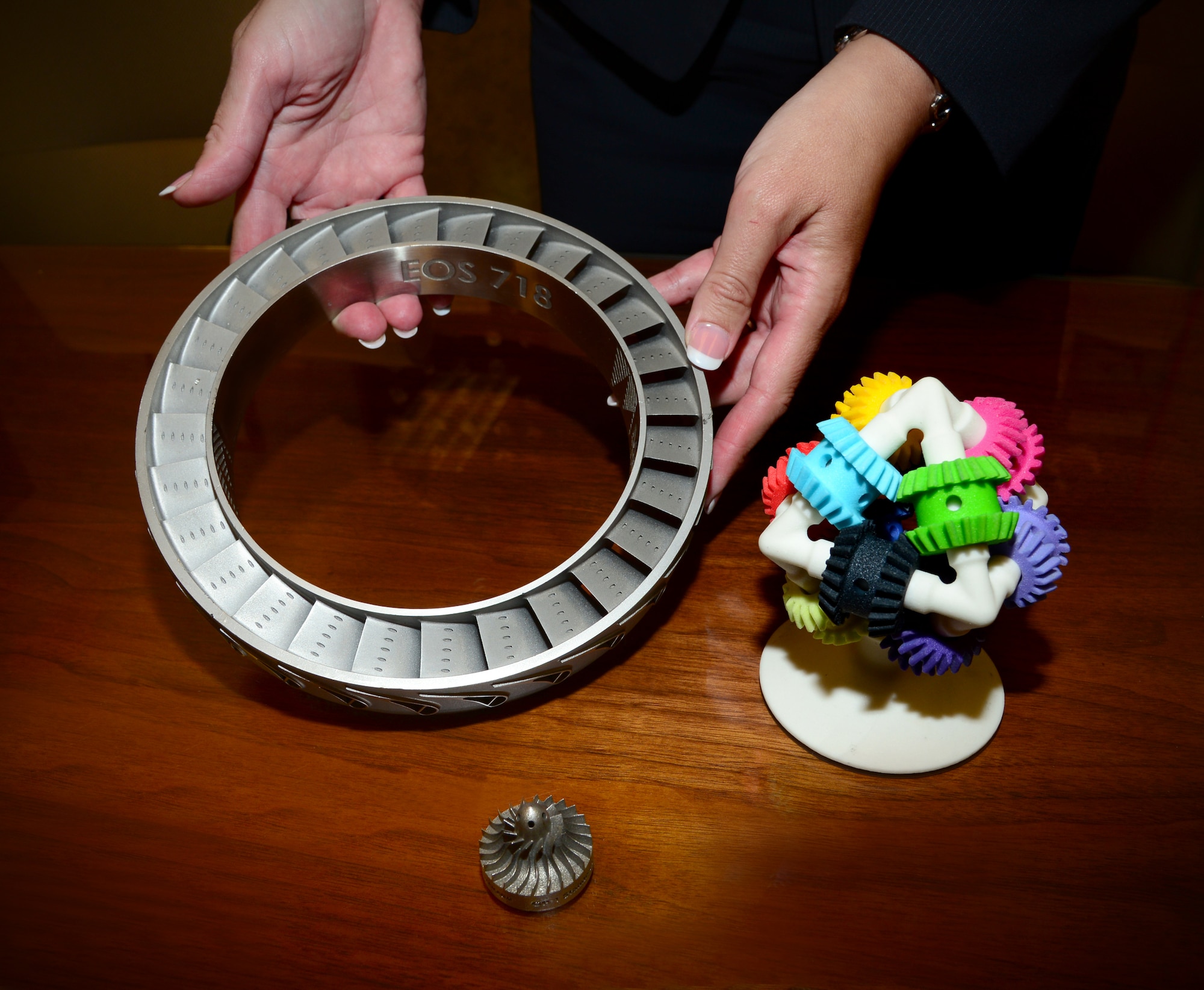 These two devices are demonstration items that the Engineering and Technical Management Directorate of the Air Force Sustainment Center, based at Tinker, uses to promote the concept of 3D printed aircraft parts. The one on the right is called "Brain Gear" and was printed on a 3D printer in one piece, as is. “It’s a plastic material, and we use this kind of printing in our MX shops today to fit check parts that we need to manufacture locally,” said EN Director Angie Tymofichuk. The other item, a titanium part, also was 3D printed but in a different fashion called Additive Manufacturing, using a laser. “The technology to make those things exists in industry today,” Ms. Tymofichuk said. “What we're pushing is standards, testing, qualification, etc., for using that technology to make parts on-demand, not having to keep stock in warehouses or having to wait on deliveries." (Air Force photo by Kelly White)