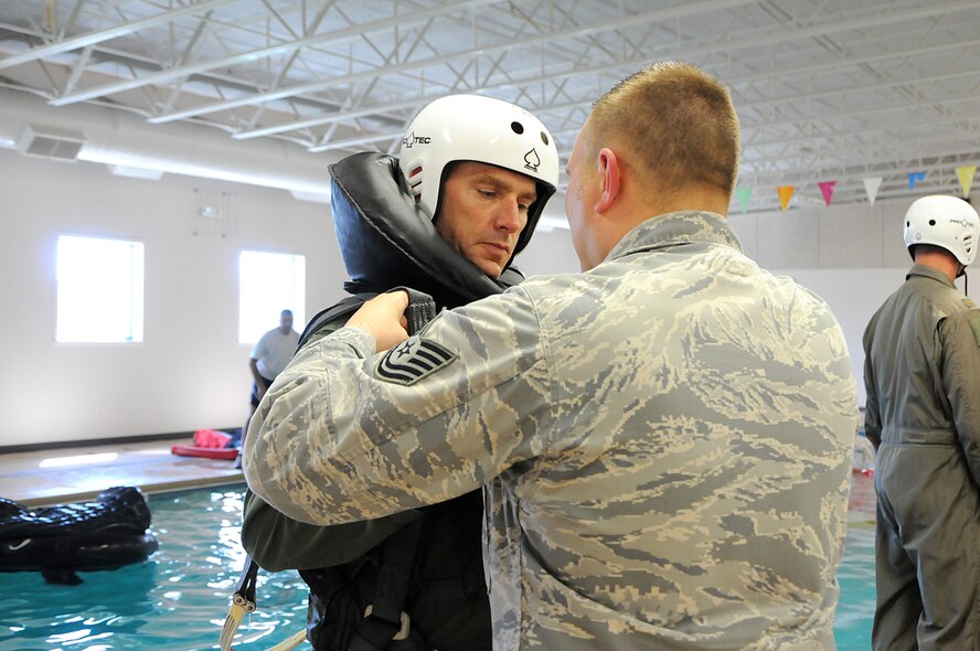 Tech. Sgt. Joshua Reddick, from the 190th Fighter Squadron (FS) Life Support, secures water survival equipment onto Idaho Air Guard pilot and 190thFS Commander, Lt. Col. Shannon Smith, during water survival training, May 5, at the Idaho State Police Training Facility in Meridian, Idaho. (Air National Guard photo by Tech. Sgt. Becky Vanshur)