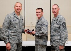 Col. Darren Hartford, 437th Airlift Wing commander, and Chief Master Sgt. Larry Williams, 437th AW command chief, congratulate Senior Airman Brian Hadraba, 437th Maintenance Squadron crew chief, as a Diamond Sharp award winner during a ceremony May 7, 2013, at the Charleston Club at Joint Base Charleston - Air Base, S.C. Diamond Sharp awardees are Airmen chosen by their first sergeants for their excellent performance. (U.S. Air Force photo/Staff Sgt. Rasheen Douglas)