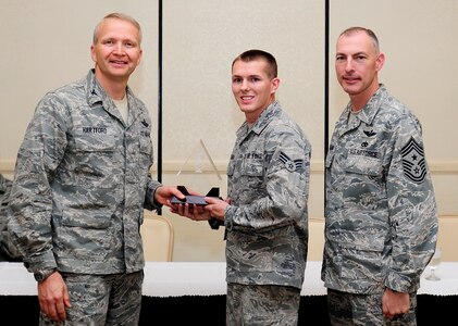 Col. Darren Hartford, 437th Airlift Wing commander, and Chief Master Sgt. Larry Williams, 437th AW command chief, congratulate Senior Airman Brian Hadraba, 437th Maintenance Squadron crew chief, as a Diamond Sharp award winner during a ceremony May 7, 2013, at the Charleston Club at Joint Base Charleston - Air Base, S.C. Diamond Sharp awardees are Airmen chosen by their first sergeants for their excellent performance. (U.S. Air Force photo/Staff Sgt. Rasheen Douglas)