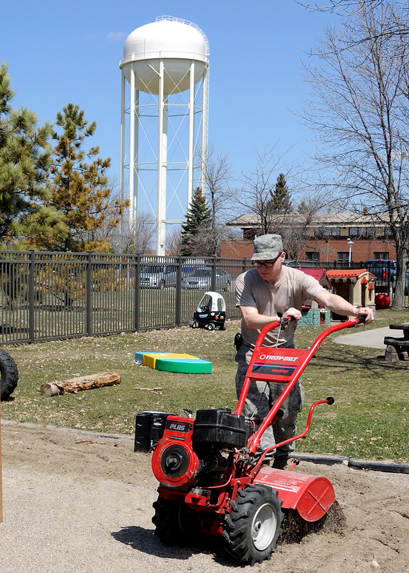 Senior Airman Daniel Anderson, 319th Civil Engineer Squadron pavement and equipment apprentice, guides a tiller around the sandbox at the Child Development Center on May 7, 2013, on Grand Forks Air Force Base, N.D. Aside from tilling, members of the 319th CES cleared the sandbox of toys and raked harmful objects out of the sand to make the playground safer as spring arrives on base. (U.S. Air Force photo/Airman 1st Class Ashley Nicole Taylor)