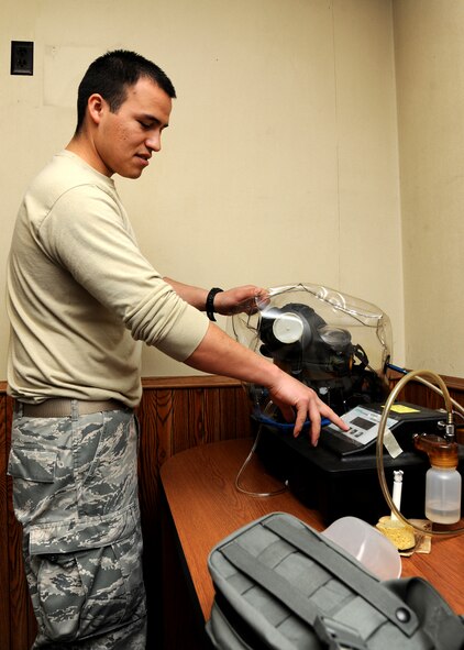 Staff Sgt. Arturo Perez, 319th Logistics Readiness Squadron individual protective equipment supervisor, uses a Joint Service Mask Leak Tester, May 6, 2013, on Grand Forks Air Force Base, N.D. After cleaning and sanitizing a mask, it is checked for any kind of leakage to see if it is still functional. (U.S. Air Force photo/Airman 1st Class Ashley Nicole Taylor)
