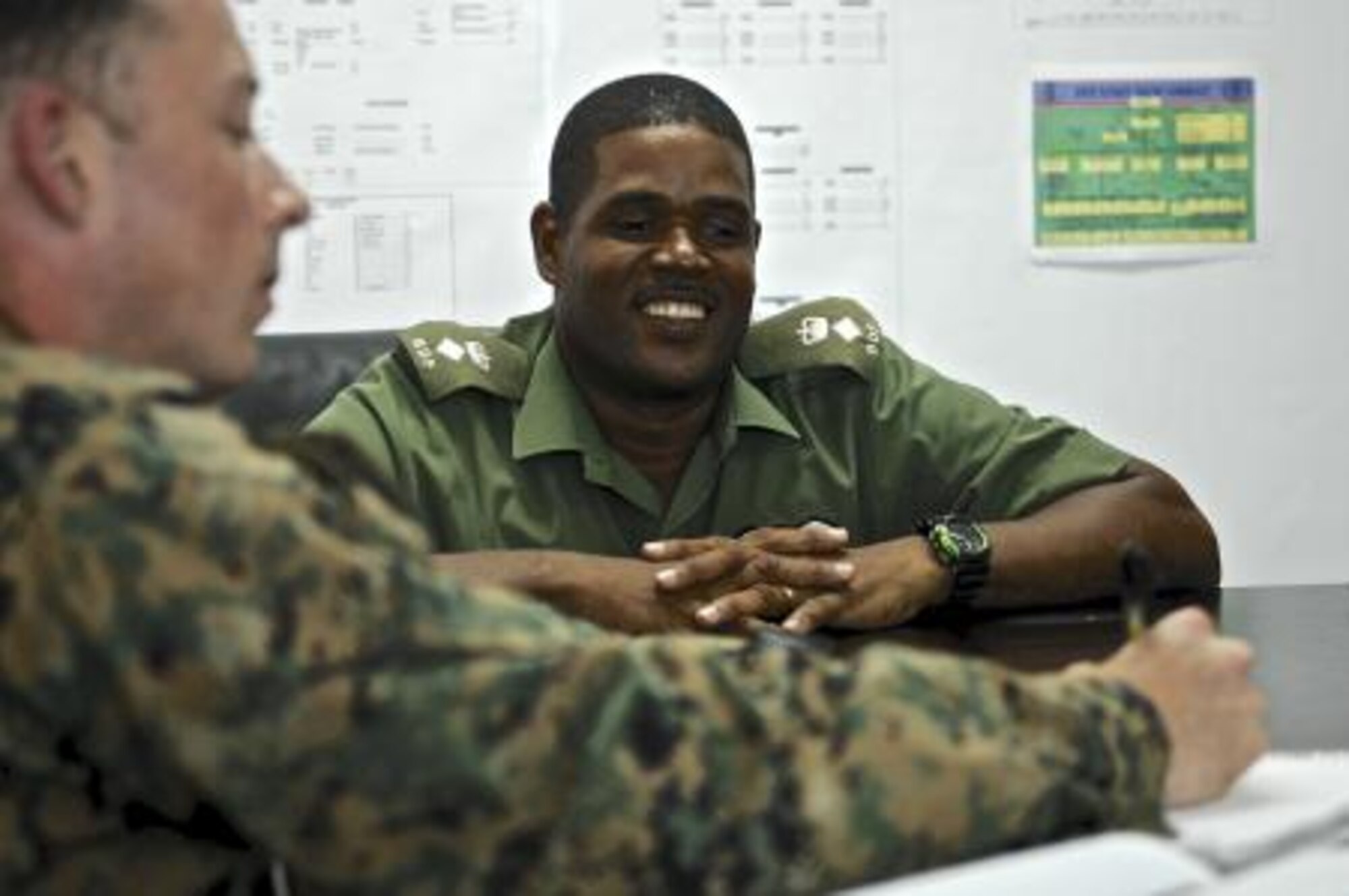 U.S. Marine Capt. Thomas Cahill, left, and U.S. Army Capt. Zulma Andrews, right, both civil affairs, share a laugh with Belize Defense Force Chief of Staff Lt. Col. Raymond Shepherd, center, during a key leader engagement May 6, 2013, at Price Barracks, Belize. The civil affairs team meets with key leaders and local communities to assess host-nation capabilities as part of an exercise known as New Horizons. New Horizons is a training exercise providing medical and dental treatment as well as constructs needed structures, such as classrooms, throughout Belize. It gives U.S., Belizean and Canadian service members the opportunity to train side-by-side in an exercise setting in order to be prepared to meet future challenges. (U.S. Air Force photo/Master Sgt. James Law)
