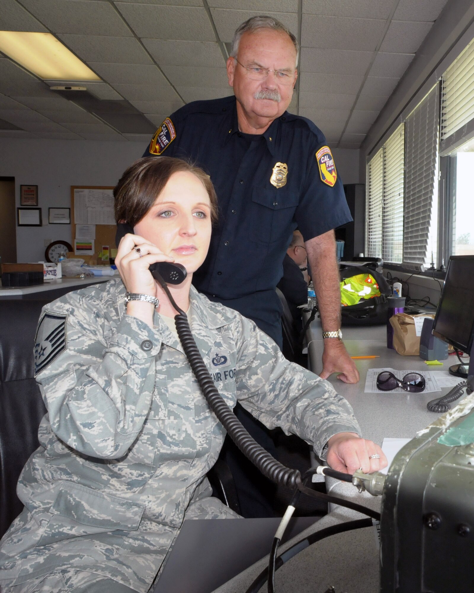 Master Sgt. Amy Zuniga of the 146th Airlift Wing and CAL FIRE officer Dan Sendek coordinate movement and reloading of CAL FIRE aircraft at the air tanker base staging out of Channel Islands Air National Guard Base in Port Hueneme, Calif. (Air National Guard photo by Senior Airman Nicholas Carzis)