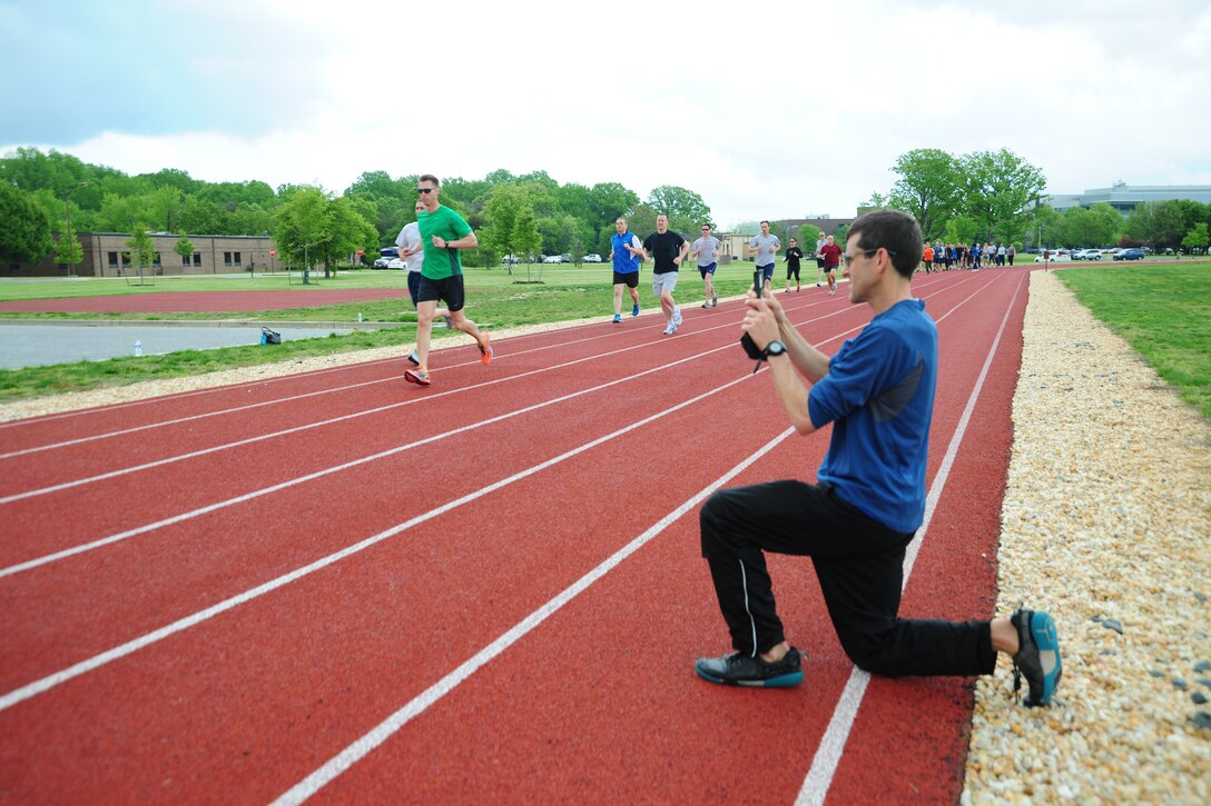 Lieutenant Colonel Mark Cucuzzella,  Air Force Marathon chief medical consultant and Natural Running Center director, video records Team Andrews members running at an Efficient Runners Seminar held May 7-8, 2013, at the East Fitness Center. The Health and Wellness Center sponsored the event. (U.S. Air Force photo/Staff Sgt. Amber Russell)