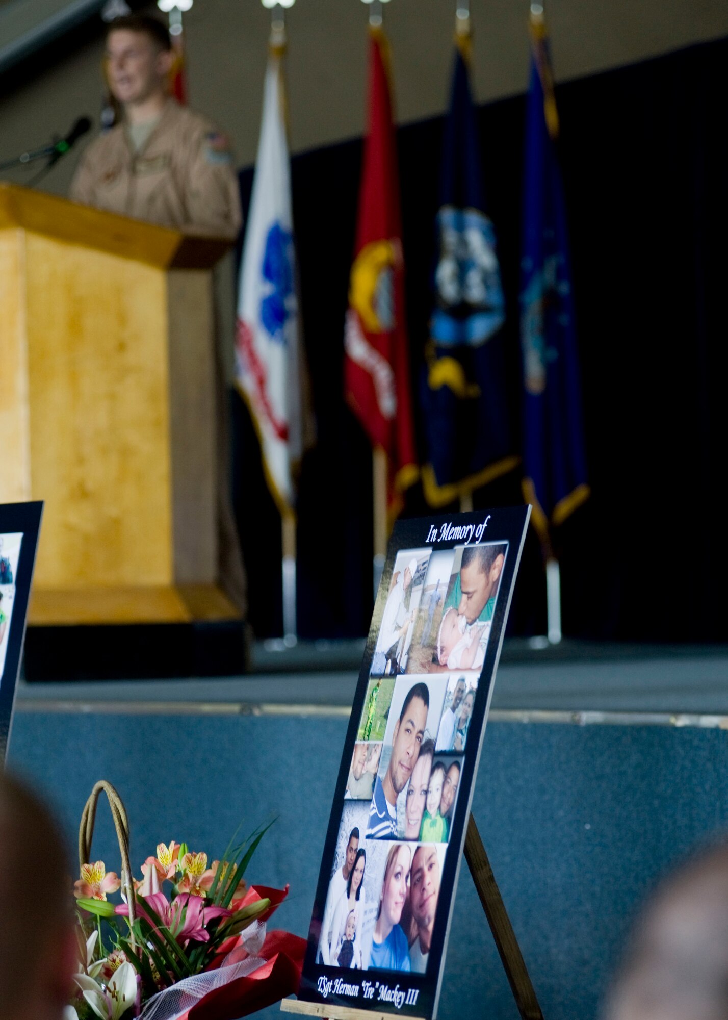 A collage featuring Tech. Sgt. Herman "Tre" Mackey III is displayed as Senior Airman Derik Melson shares memories with audience members during  a memorial service May 9, 2013, at Transit Center at Manas, Kyrgyzstan. "Tre was the type of guy that had a smile that could light up a room," Melson said. Mackey was Melson's supervisor, friend and mentor. (U.S. Air Force photo/Staff Sgt. Stephanie Rubi) 