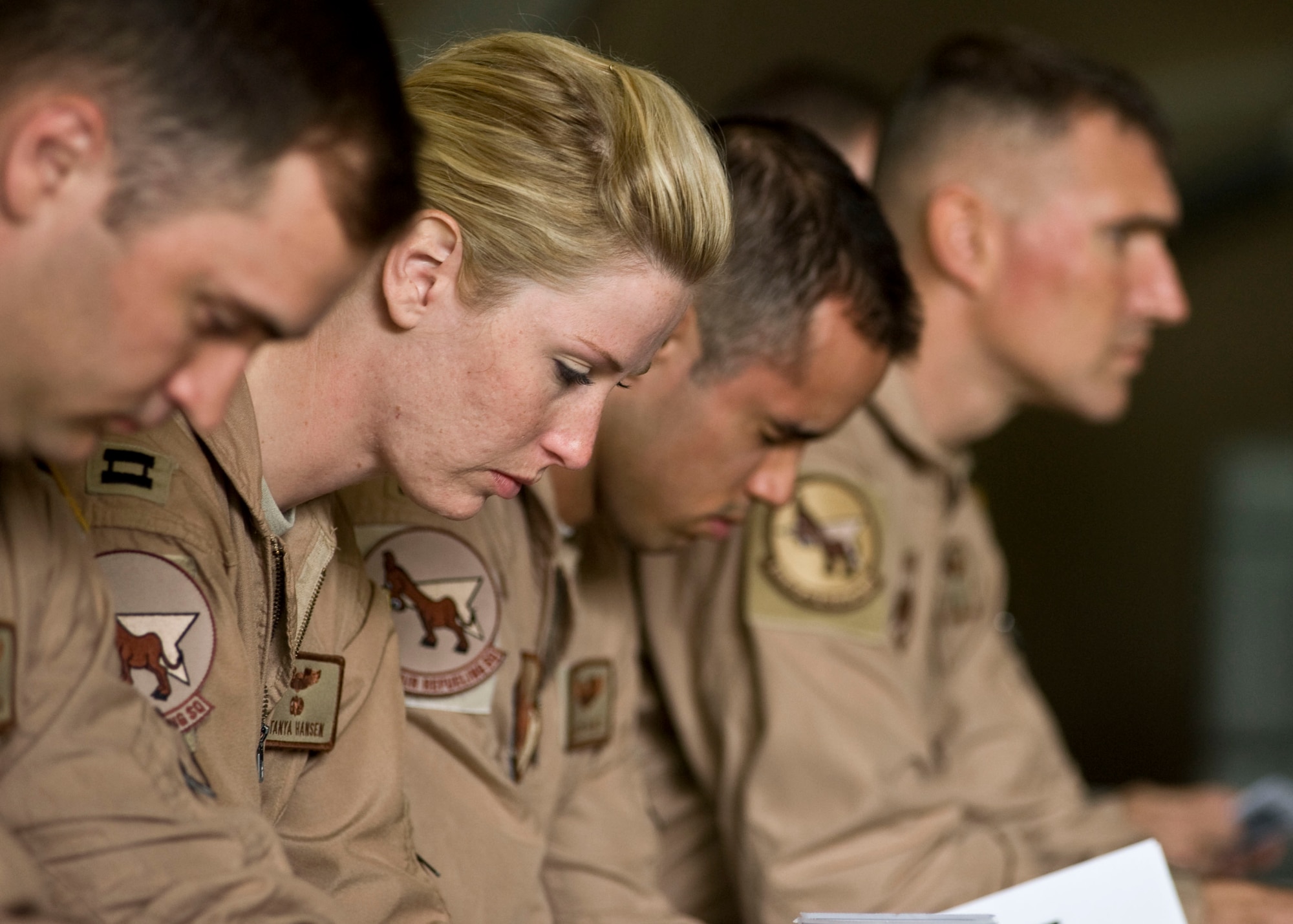 Airmen from the 22nd Expeditionary Air Refueling Squadron bow their heads during a memorial service May 9, 2013, at Transit Center at Manas, Kyrgyzstan. During the ceremony Airmen were able to share stories, honor and pay their respects to Capt. Mark "Tyler" Voss, Capt. Victoria "Tori" Pinckney, and Tech. Sgt. Herman "Tre" Mackey III. (U.S. Air Force photo/Staff Sgt. Stephanie Rubi)