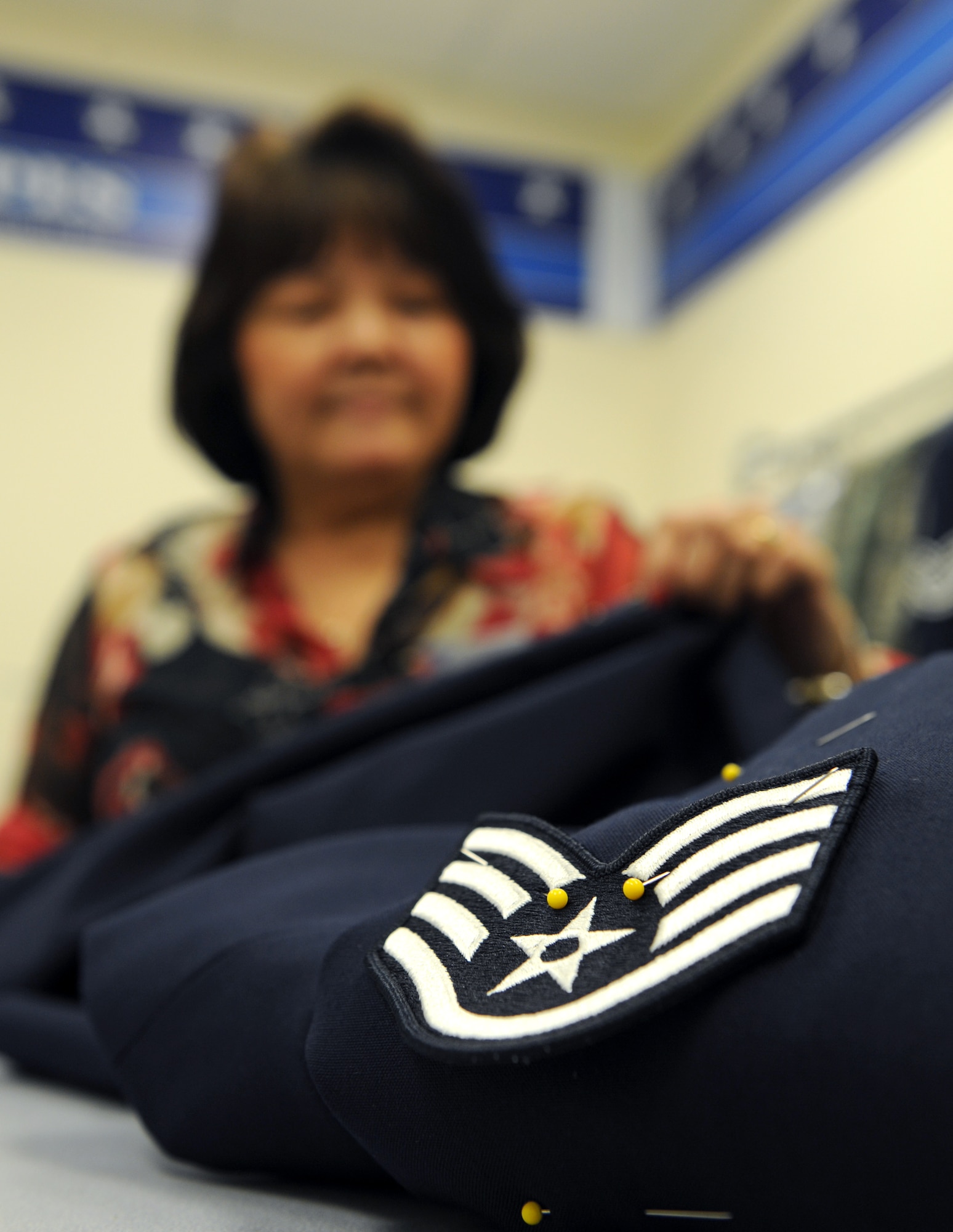 Tam Harper, Army & Air Force Exchange Service alterations seamstress, prepares to sew on staff sergeant stripes to a female mess dress on Barksdale Air Force Base, La., May 8, 2013. The AAFES Cleaners and Alterations shops are open Monday to Friday from 8:00 a.m. to 6:00 p.m., Saturday from 9:00 a.m to 4:00 p.m. and are closed every Sunday and on holidays. (U.S. Air Force photo/Airman 1st Class Benjamin Gonsier)
