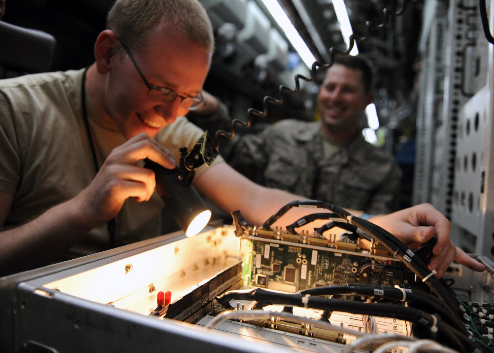 SOUTHWEST ASIA -- Senior Airman Ross Lemp and Tech. Sgt. Michael Sequin, 763rd Expeditionary Reconnaissance Squadron electronic warfare maintainers, examine the information systems onboard a RC-135V/W Rivet Joint May 6, 2013, at the 379th Air Expeditionary Wing, Southwest Asia. The RC-135’s are primarily used as an intelligence, surveillance and reconnaissance platform; picking up real-time information on oppositional forces. Lemp and Sequin are deployed from Offutt Air Force Base, Neb. (U.S. Air Force photo/Staff Sgt. Joel Mease)