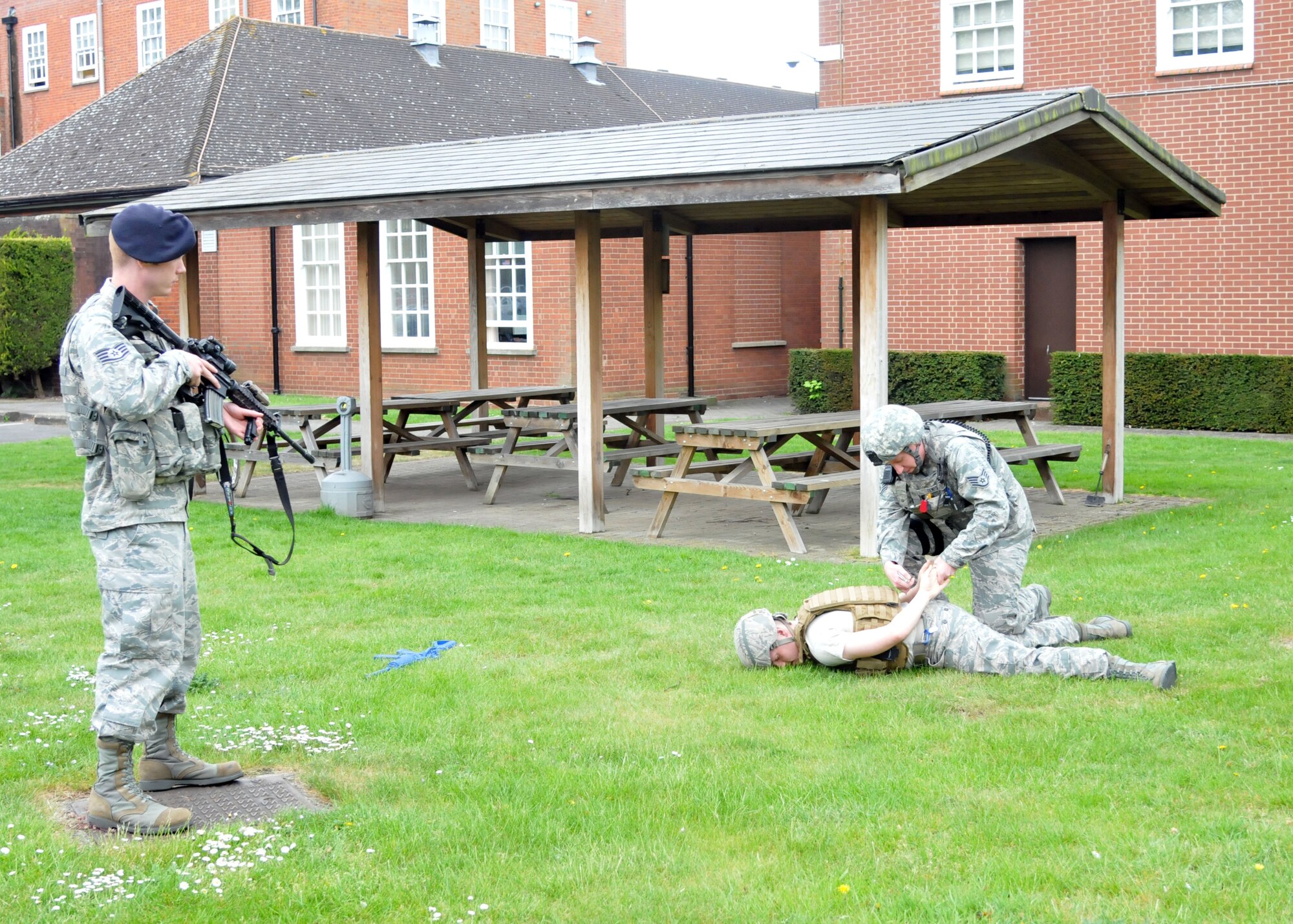 Two 100th Security Forces Squadron Airmen respond to a 911 emergency call about a potential active shooter situation on RAF Mildenhall, England. Patrolmen apprehend the suspected assailant, get his statement and verify the facts prior to his release. [(Note: The photo has been staged to depict an actual situation which occurred April 20, 2013, during the unit effectiveness inspection.) (U.S. Air Force photo by Airman 1st Class Kelsey Waters/Released)]