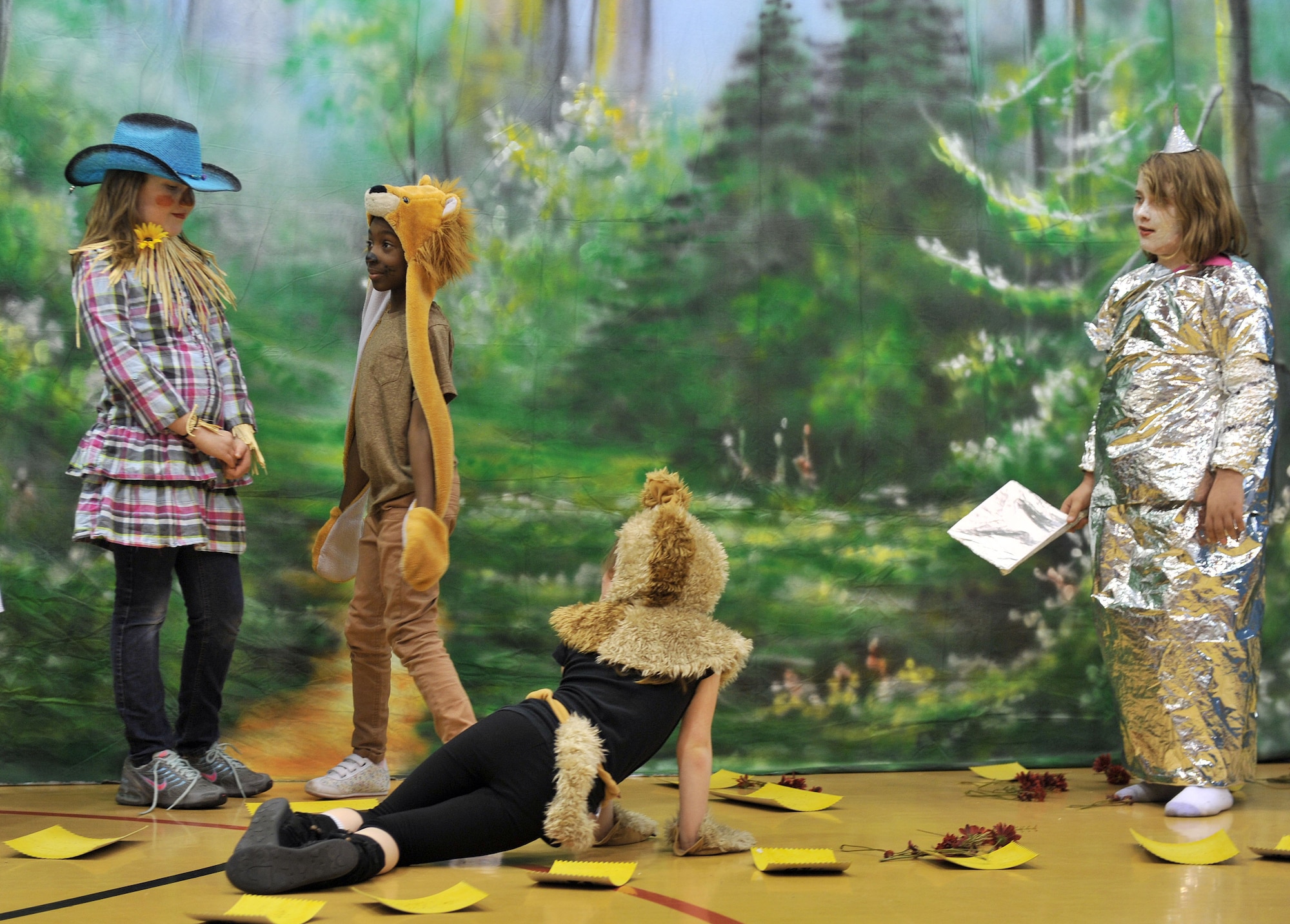 From left, the Scarecrow, played by Sophie Fields; the Cowardly Lion, played by Ahmira Palmer; Toto the dog, played by Paige Lacey; and the Tin Man, played by Jaime Manson, all come to Dorothy’s aid in finding the Wizard and defeating the Wicked Witch in the production of the “Wizard of Oz” May 7, 2013, at the youth center on RAF Mildenhall, England. Twenty-four children participated in the play while staff, parents and other family members watched. (U.S. Air Force photo by Tech. Sgt. Stacia Zachary/Released)