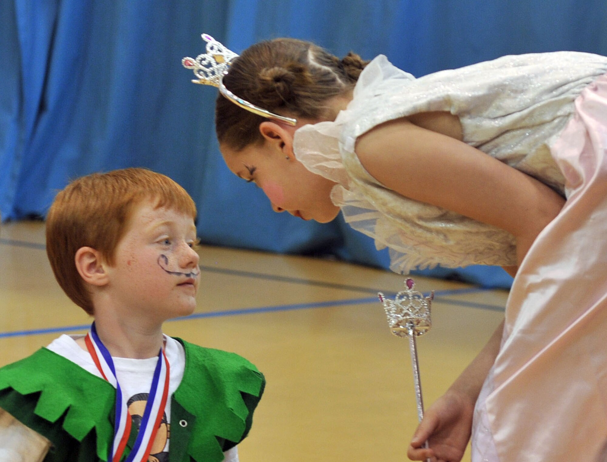 From left, The Mayor of Munchkinland, played by Adam Hardin, receives last-minute advice from the Good Witch, played by Calla Fisher, just before the production of the “Wizard of Oz” starts May 7, 2013, at the youth center on RAF Mildenhall, England. Twenty-four children worked for months learning their lines and creating their costumes for the production. The youth center routinely hosts events to showcase the children's talents. (U.S. Air Force photo by Tech. Sgt. Stacia Zachary/Released)