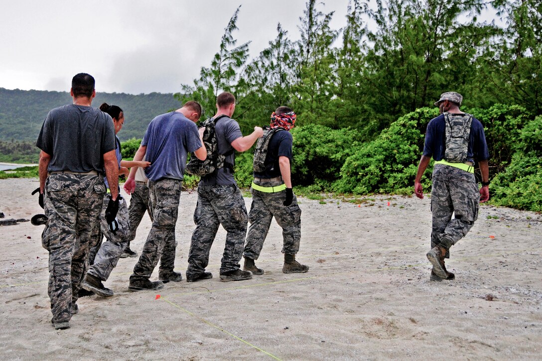 Members from the 36th Mobility Response Squadron perform a team-building exercise during a training day at Andersen Air Force Base, Guam, May 2, 2013. Each 36th MRS member faced challenges designed to test physical fitness, individual and team decision-making skills during the rescue scenario. (U.S. Air Force photo by Airman 1st Class Marianique Santos/Released)