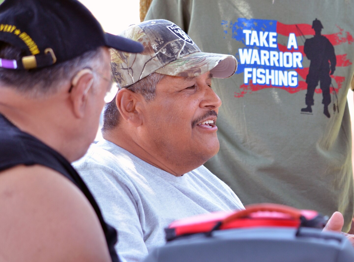 Daniel Hernandez shares a story with volunteer helpers from the Monache Marauders baseball team. Photo cropped for emphasis.