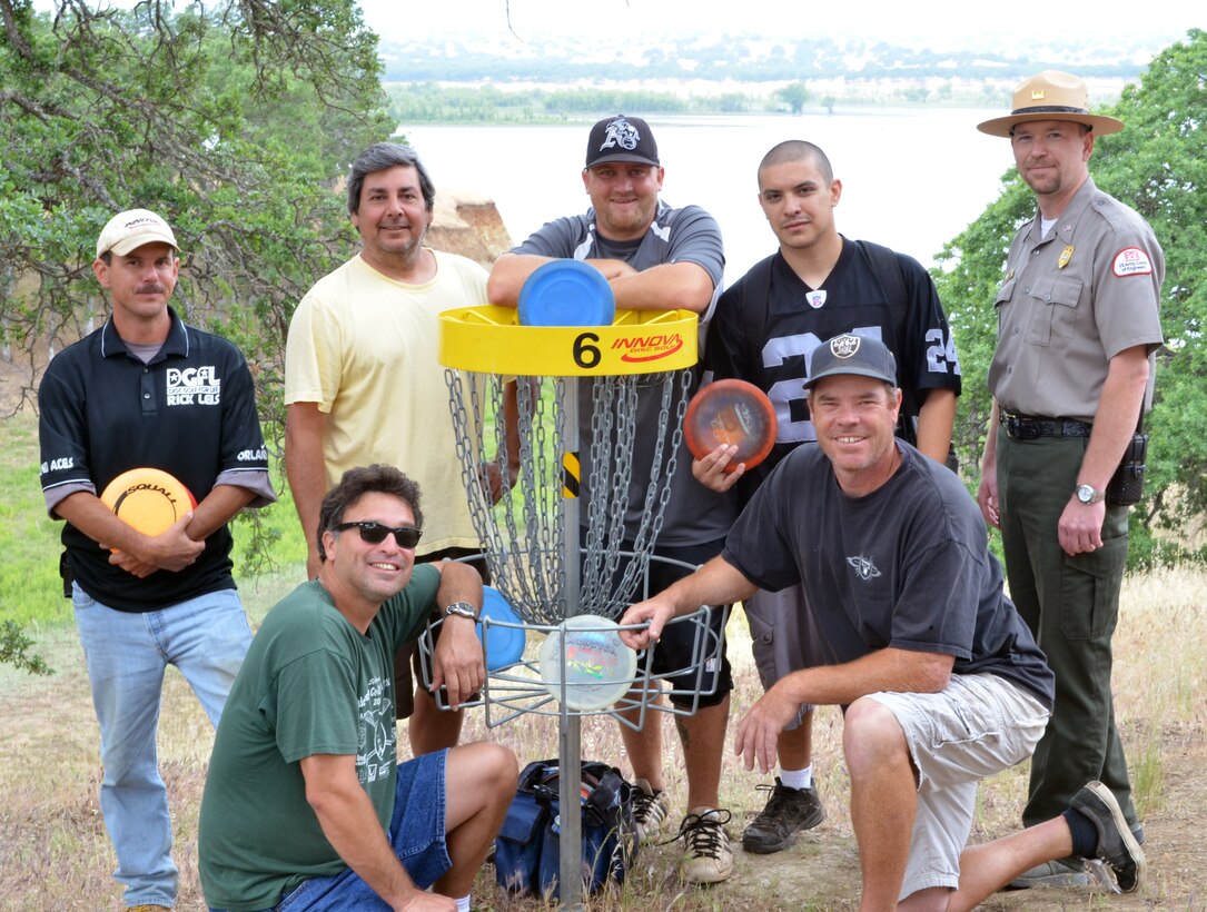 Members of the Orland ACES Disc Golf Club pose for a shot at the sixth basket of the Black Butte Lake Disc Golf Course near Orland Buttes Campground at the U.S. Army Corps of Engineers Sacramento District park near Orland, Calif. Pictured from left to right: Rick Leis, Paul Scholz (kneeling), Gary Charlesworth, Andy Herbert, Robert Duran, Dale Bouttote (kneeling) and Bill Miller, Black Butte Lake senior ranger. (U.S. Army Corps of Engineers photo by Robert Kidd/Released)