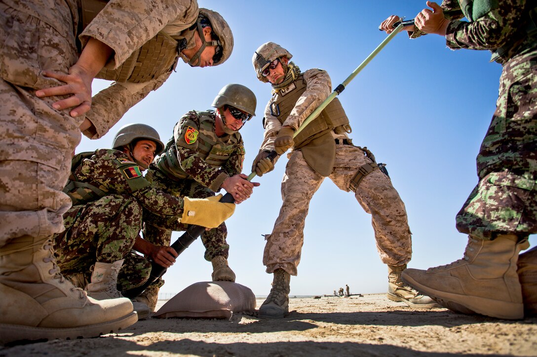 U.S. Marine Corps Staff Sgt. David Denseley, center, helps Afghan mortarmen clean the bore of a 60mm mortar at a mortar range near Camp Shorabak in Afghanistan's Helmand province, May 4, 2013. Denseley is assigned to the Regional Corps Battle School. 