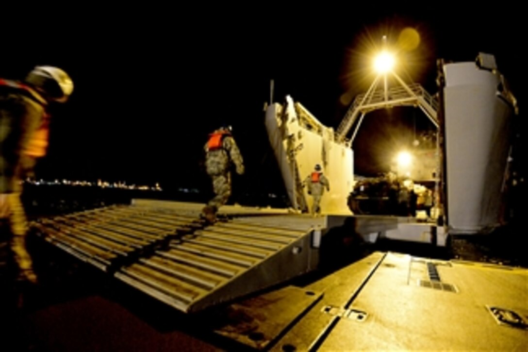 U.S. service members walk into the logistics support vessel USAV Lt. Gen. William B. Bunker (LSV 4) to offload Marine Corps M1A1 Abrams tanks during the Combined Joint Logistics Over the Shore naval exercise in Pohang, South Korea, on April 19, 2013.  The exercise is designed to improve logistics interoperability, communication and cooperation between the United States and South Korea forces.  