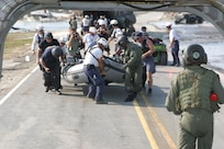 Staff Sgt. Brian Ogle helps members of a FEMA search team carry their boat onto a CH-47 Chinook helicopter while Staff Sgt. Rodney Thomas (back to camera) makes sure the loading goes safely. Both Soldiers are members the Army Reserve’s B Co., 5th Battalion, 159th Aviation Regiment, headquartered at Fort Eustis, Va. It was the first Army Reserve unit mobilized for recovery operations in the aftermath of Hurricane Katrina