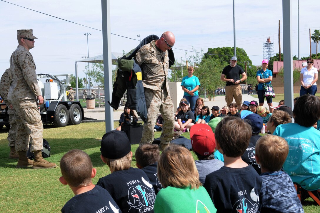Marines with the explosive ordinance disposal unit for Marine Corps Air Station Yuma demonstrate what kind of work they conduct in the field to the children from local schools taking part in the Intro to Devil Dogs 101 childrens' tour, May 8. Some of the students that attended the Intro to Devil Dogs 101 were military dependents and had a chance to share their parent's military training with fellow classmates.