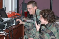 Col. Babette Lenfant works with Staff Sgt. Ethan Mabry during the Defense Interoperability Communications Exercise 06 to test a system that can tie together several different types of communications systems. DICE06 took place at Joint Task Force Civil Support Headquarters on Fort Monroe, Va. 